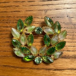 Costume jewelry brooch in green glass, set in gold tone metal - vintage